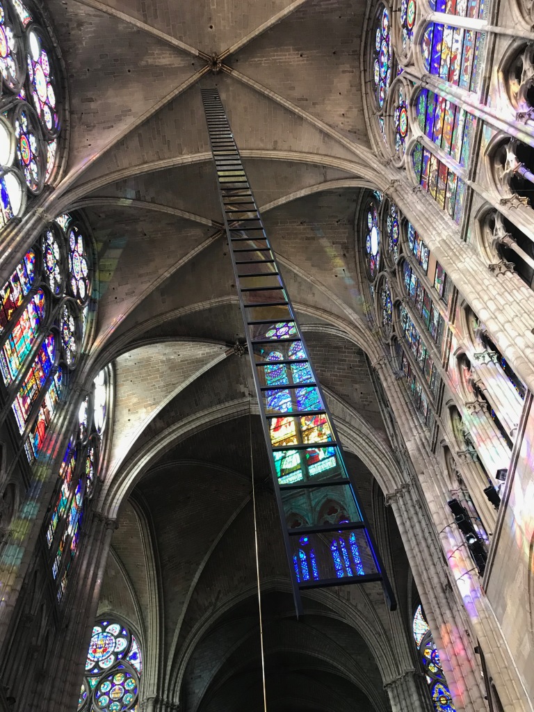oeuvre d'art contemporain suspendu au plafond de la basilique, vitraux sur le côté